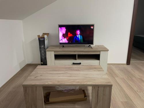 a living room with a tv and a wooden table at Apartman Jela Srebrno jezero in Ostrovo