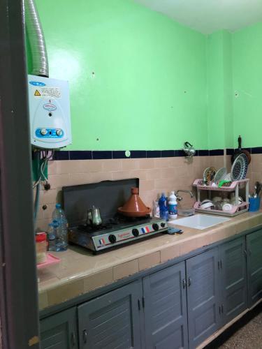 a kitchen counter with a stove and a sink at Heart appartement Al massira in Agadir
