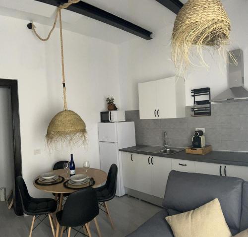 a kitchen with a table and chairs in a room at Plaza de la fuente Granadilla de Abona Tenerife sur Only Adults con terraza privada in Granadilla de Abona