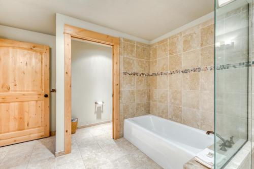 a bathroom with a tub and a glass shower at #401 Grand Lodge South Penthouse in Government Camp