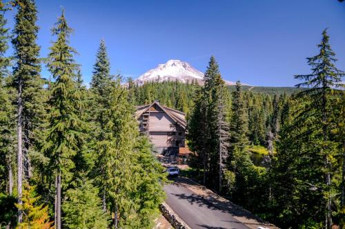 a house in the forest with a mountain in the background at #401 Grand Lodge South Penthouse in Government Camp
