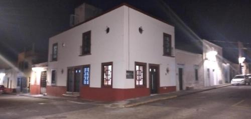 a white and red building on a street at night at Suites del Centro Executive in Morelia