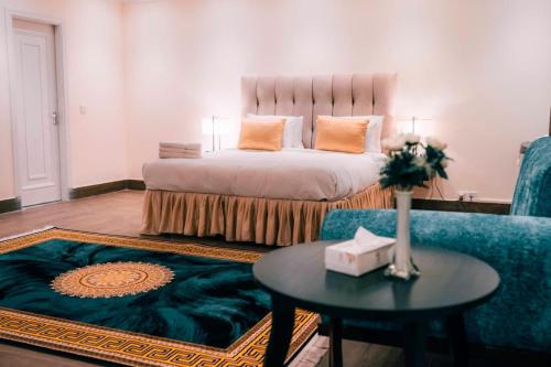 ein Schlafzimmer mit einem Bett, einem Tisch und einem Sofa in der Unterkunft Falettis Grand Bahawalpur in Bahawalpur