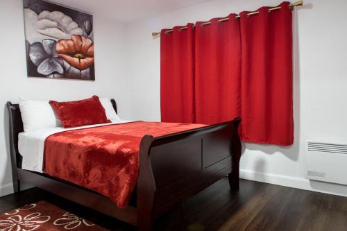 a bedroom with a bed with a red curtain at Motel LA RÉFÉRENCE in Trois-Rivières