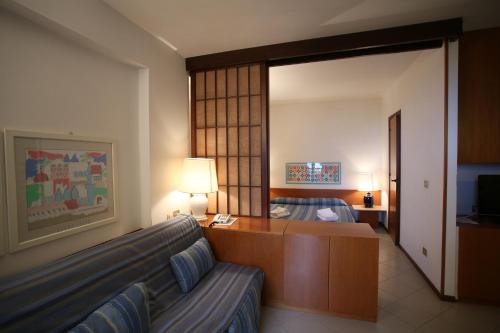 a hotel room with a couch and a bed at Holiday Homes Marina in Punta Ala