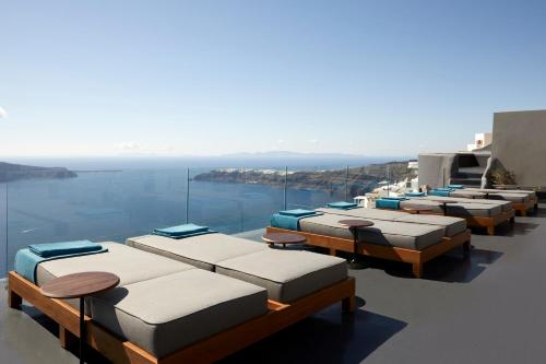 a row of beds sitting on top of the water at Kivotos Santorini - Preferred Hotels & Resorts in Imerovigli