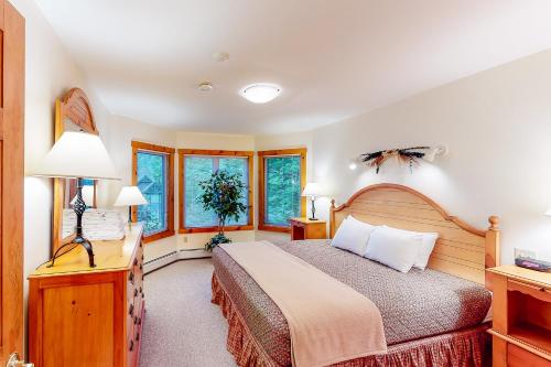 a bedroom with a bed and two windows at Summit Solitude & Latitude Adjustment in Jay