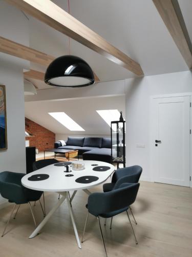 a dining room with a white table and chairs at Charming Apartment in Kaunas Old Town with Balcony in Kaunas
