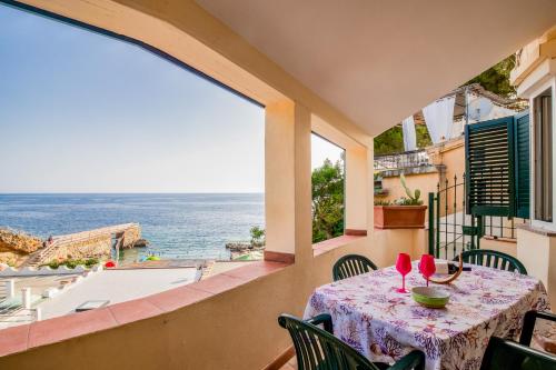 a table on a balcony with a view of the ocean at Casa Stecchi in Capoliveri