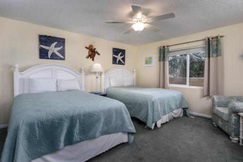 a bedroom with two beds and a ceiling fan at Surf Dweller 207 in Fort Walton Beach