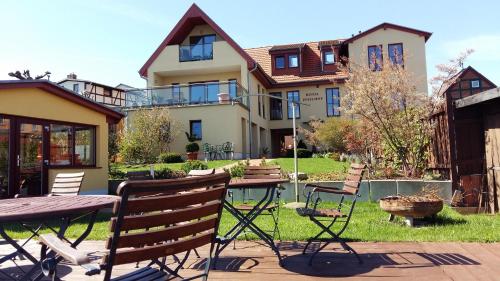 a house with a table and chairs in the yard at Hotel Inselhof in Malchow