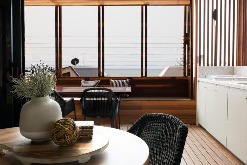 a kitchen and dining room with a table and chairs at Reflections Bonny Hills - Holiday Park in Lake Cathie