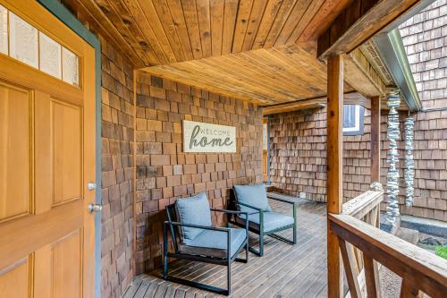 a porch with two chairs and a table on it at Port Susan Bay in Sunny Shore Acres
