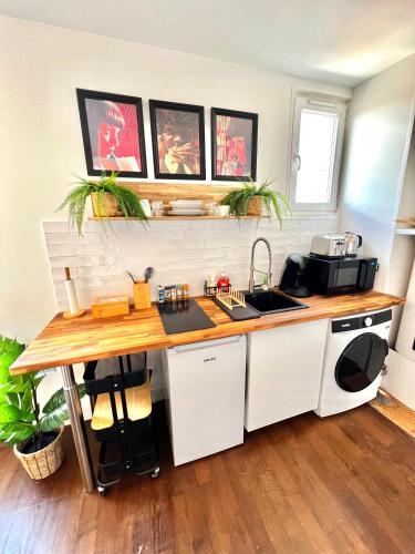 une cuisine avec un évier et un plan de travail dans l'établissement Le Cocon proche Paris JO 2024 Centre-ville, à Saint-Gratien