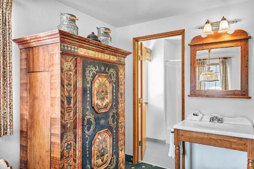 a bathroom with a large wooden cabinet next to a sink at Hotel Pension Anna in Leavenworth