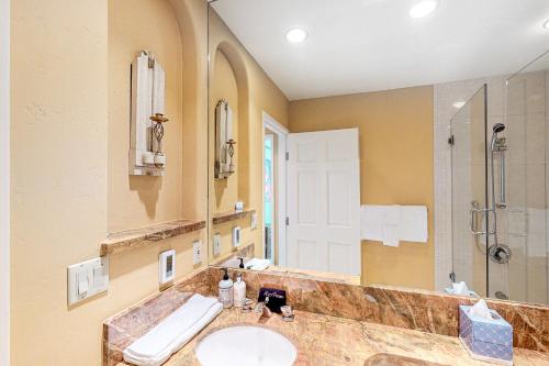 uma casa de banho com um lavatório, um chuveiro e um espelho. em Northstar 22 - The North Star em Telluride