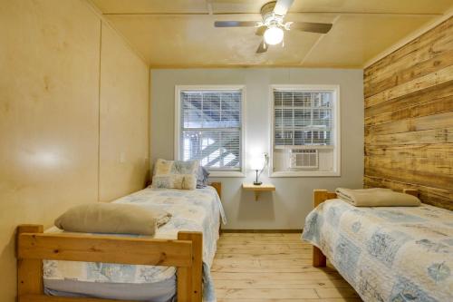 a bedroom with two beds and two windows at Golden Meadow Getaway Waterfront Retreat with Deck in Golden Meadow