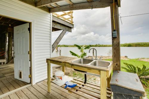 una cocina con fregadero en una terraza junto a una puerta en Golden Meadow Getaway Waterfront Retreat with Deck, 