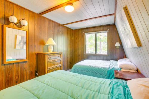 2 camas en una habitación con paneles de madera en Crystal Mountain Cabin with Cozy Fireplace!, en Thompsonville