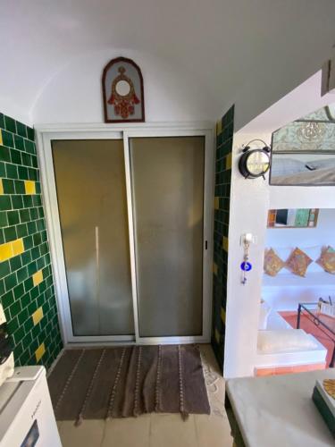 a bathroom with a sliding glass door in a room at Dar chelbia in Hammamet