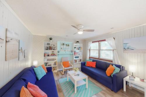 uma sala de estar com um sofá azul e almofadas coloridas em Offshore Oasis KDH101 em Kill Devil Hills