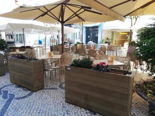 a restaurant with tables and chairs and umbrellas at Aveiro Soul & Heart apartment in Aveiro