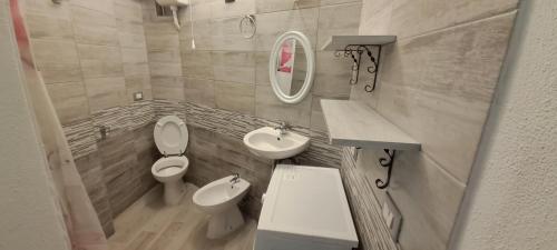 bagno con servizi igienici, lavandino e specchio di Stella Marys a Olbia