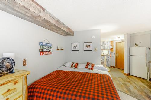 a bedroom with a bed with an orange plaid blanket at Iron Horse Resort D3084 in Winter Park