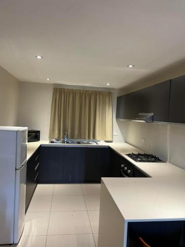 a kitchen with black and white cabinets and a refrigerator at Pacific FairPrice in Nadi