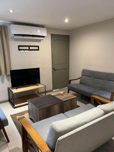 uma sala de estar com 2 sofás e uma televisão de ecrã plano em Pacific FairPrice em Nadi
