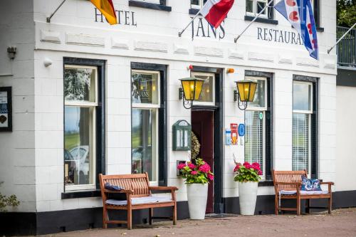 three benches in front of a building with flowers at Hotel Jans in Rijs