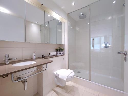 a bathroom with a shower and a toilet and a sink at Fully Serviced Two Bed Apartment by ExCeL & O2 in London