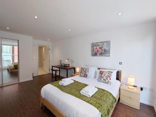 a white bedroom with a large bed with pillows at Fully Serviced Two Bed Apartment by ExCeL & O2 in London