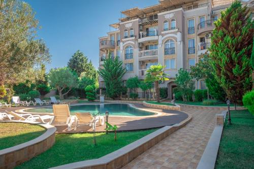 a resort with a pool and a building at Melia lux apartment in Ravda
