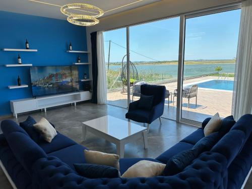 a living room with a blue couch and a large window at Top Villas Durres in Durrës