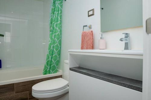 een witte badkamer met een toilet en een wastafel bij Las Orquideas Zona 10 in Guatemala