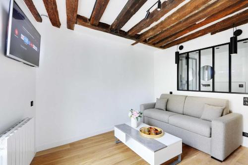 a living room with a couch and a table at Studio 2P renovated rue des Archives Marais Clim 4 in Paris