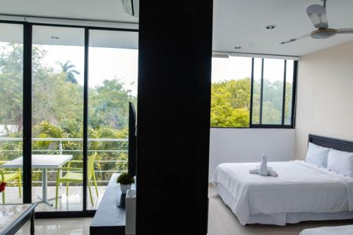 a bedroom with a bed and a view of a balcony at Hotel & Suites Yuca Ville Siglo XXI in Mérida