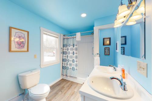 a blue bathroom with a toilet and a sink at Blue Lagoon Escape A&B in Boothbay