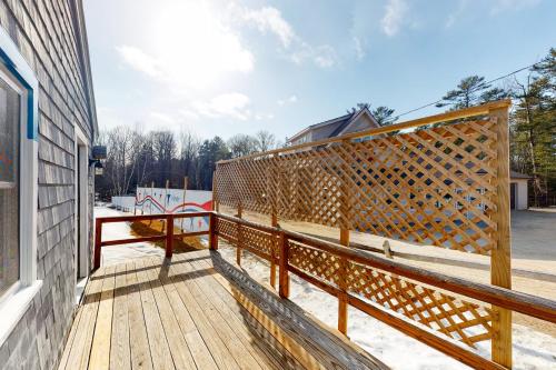 a wooden deck with a fence on the side of a house at Blue Lagoon Escape A&B in Boothbay