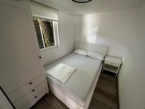 a small white room with a bed and a window at OASIS Aqualuna & Terme Olimia G110 in Podčetrtek