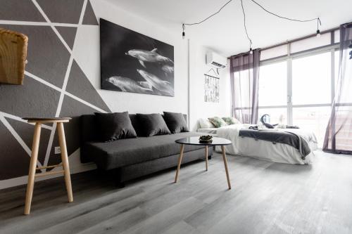 un soggiorno con un divano e un letto di Modern studio with see and city view a Benidorm