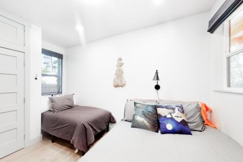 a white bedroom with a bed and a window at Driftwood Duet in Bandon