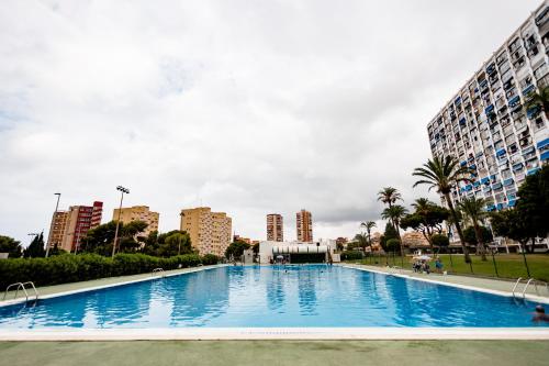 a large swimming pool in a city with tall buildings at Modern studio with see and city view in Benidorm