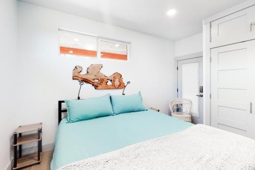 a bedroom with a bed with blue pillows at Driftwood Duet in Bandon