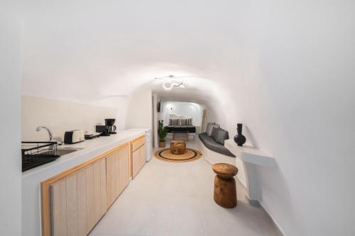 a kitchen with white countertops and an archway at Spilia Caves Santorini in Akrotiri