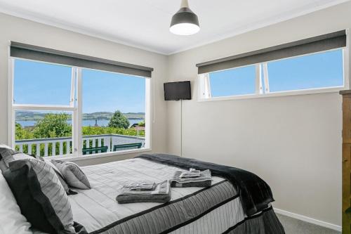 a bedroom with a large bed with a balcony at Lakeview's On Richmond in Taupo