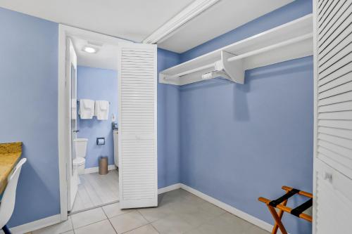 La salle de bains est pourvue de toilettes et de murs bleus. dans l'établissement 1354 Ship Watch, à Fernandina Beach