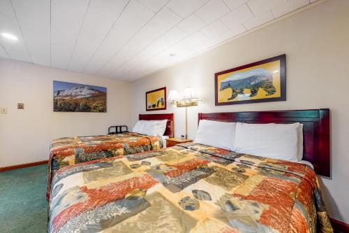 a hotel room with two beds and paintings on the wall at Riverbank Connecting Rooms 3 & 5 in Lincoln