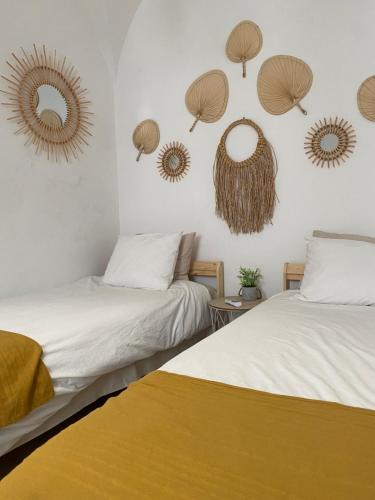 2 Betten in einem Zimmer mit Spiegeln an der Wand in der Unterkunft VISIT MOURA - Solar das Flores in Moura